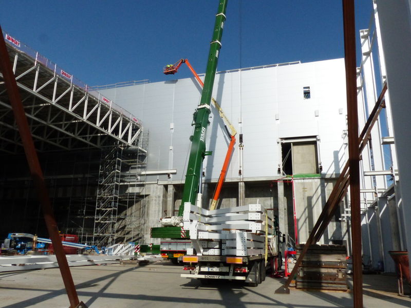 Sandwich panels are fully installed on the south side and roof trusses are ready to be installed for the remaining part of Experimental Hall 1.